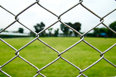 铁丝围栏和足球场土地足球安全金属白色天空栅栏绿色院子运动图片