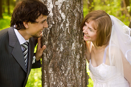 快乐的年轻新娘和新郎戒指乐趣婚礼花朵男人树木联盟场地女士女性图片