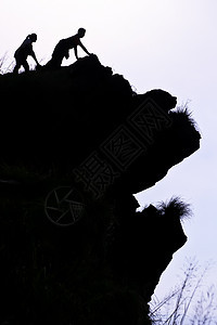 人类在山顶上冒险太阳闲暇石头岩石顶峰男人高度力量登山者图片