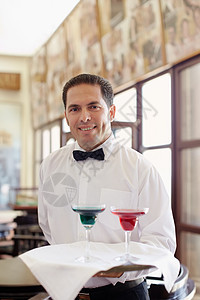 餐厅里拿着托盘站着的服务员职业桌子领结相机拉丁男人中年人服务成人饮料图片