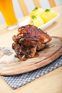 巴伐利亚烤猪肉盘的细细细节饺子棕色食物褐色胡椒烹饪关节木板盘子啤酒图片