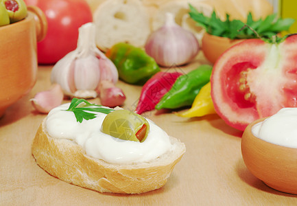 带奶油奶酪和橄榄的包面包小吃辣椒木头食物木板香菜面包盘子蔬菜早餐图片