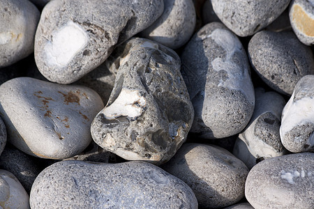 沿海岸的弗林斯通卵石硅胶石头瓦砾巨石地面碎石砾石圆形灰色图片