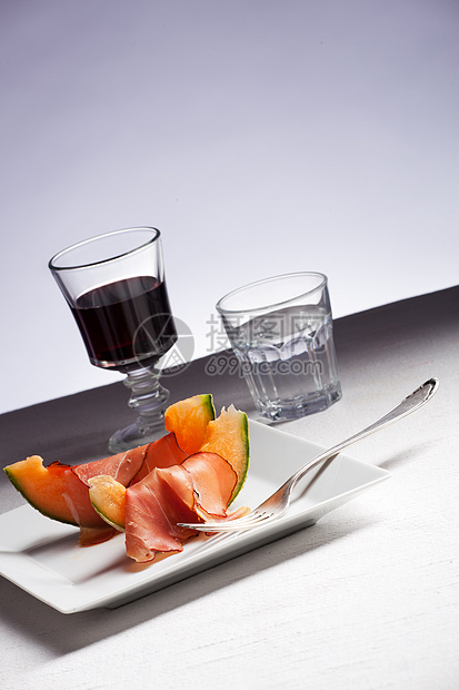 火腿和瓜瓜在盘子上切片水果起动机橙子茶点食物玻璃用餐美食红色图片