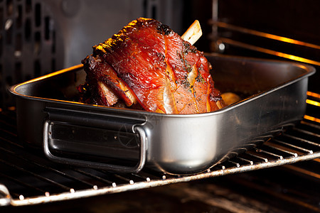 烤箱中猪肉的一顿关节胡椒火炉木板蔬菜褐色食物烹饪棕色美味图片