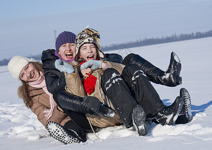 三个快乐的姐妹在冬天滑雪孩子手套微笑青春期乐趣享受行动衣服下雪游戏图片