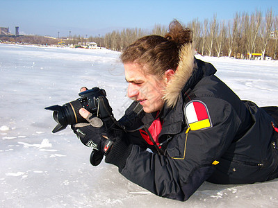 人类在冬天拍摄冰冻的海水季节裂缝摄影师摄影男人蓝色夹克天空相机冒险图片