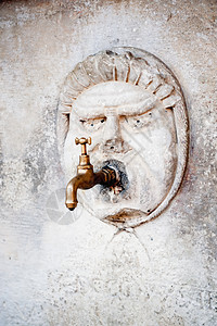 墙上布雷斯水龙头和雕刻的石头脸大理石旅游龙头历史性喷泉建筑金属雕塑滴水石头图片