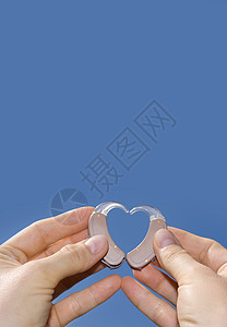 显示助听器的心脏形状天空乐器健康耳朵手指配饰棕色蓝色医疗棕榈图片