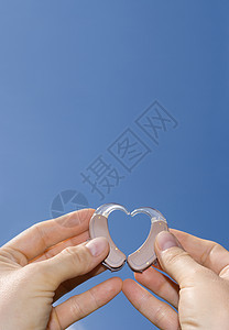 显示助听器的心脏形状棕色手指健康乐器配饰棕榈医疗听力天空耳朵图片