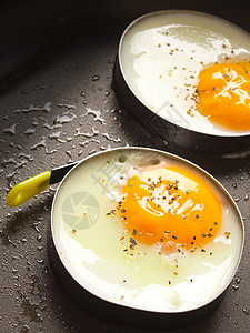 煎蛋平底锅戒指早餐金属蛋黄黑色食物白色背景图片