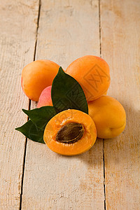 木制桌上的杏子素食石头农业甜点食物桌子有机食品叶子图片