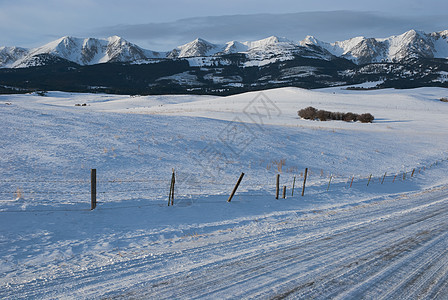 美国蒙大拿州加拉廷县冬季清晨Briger山区山脉 乡村公路和雪雪铺设的牧场图片