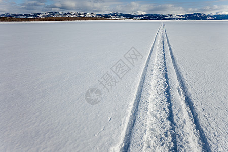 冰冻湖上的滑水轨迹地面山脉小路粉末痕迹寂寞农村旅行滑雪乐趣图片