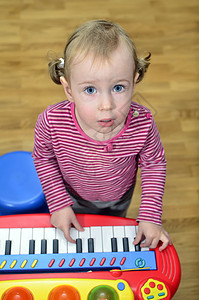 小女孩弹琴的时候童年头发音乐家婴儿教训键盘演员钢琴学习音乐图片