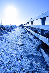 在悬崖上行走的雪覆盖路径图片