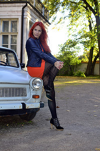 在旧车旁边的红发女孩红色发型车辆头发汽车女性化妆品冒充女士情感图片