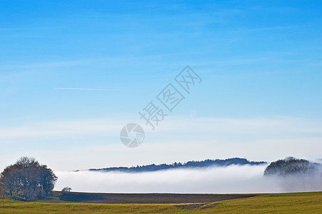 秋天降雾湿度高地蓝色天空薄雾阴霾季节性天气草地图片