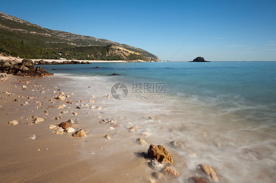 海滩上有很棒的岩石海洋石头海浪天空阳光风景地平线海岸线绿色蓝色图片