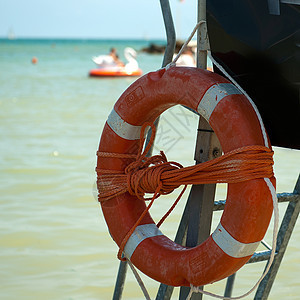 海滩上的救生艇安全自由板条晴天浮标蓝色车轮木头情况警卫图片