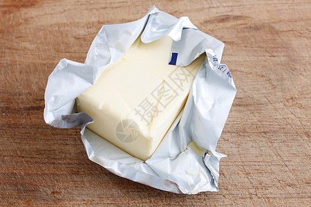 黄油黄色白色金子产品包装早餐奶制品奶油厂奶油木板背景图片