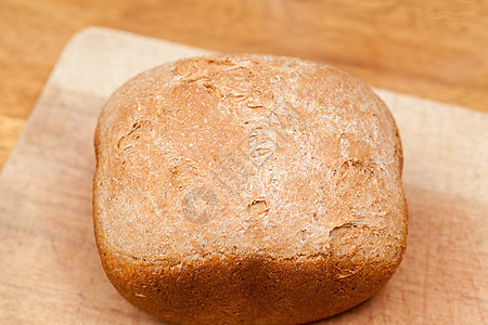 小麦面包 在机器中烘烤棕色饮食烹饪工作室糖类木板木头白色桌子脆皮图片