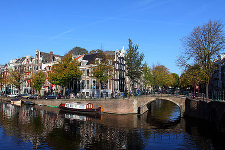 宁静的阿姆斯特丹运河和家用船自行车联盟天空教会首都反射城市房子传统历史图片