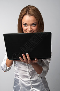 携带膝上型电脑的妇女幸福技术工人衣服笔记本快乐人士电子商务白色办公图片