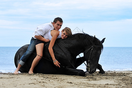 两匹马在海滩上骑马幸福黑色微笑恋人青少年男人女孩舞步宠物夫妻图片