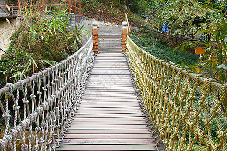 在丛林雨林中冒险的木绳悬吊桥远足旅游踪迹叶子建筑荒野木头旅行植物公园图片