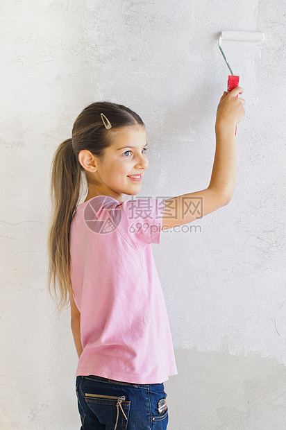 快乐的女孩画墙壁图片