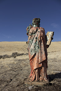 一个无处可逃的死灰复燃的宗教雕像女士蓝色蓝天礼服女孩草地上帝红色黄色图片