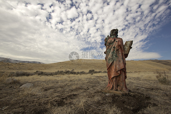 一个无处可逃的死灰复燃的宗教雕像蓝色蓝天上帝草地女孩黄色红色女士礼服图片