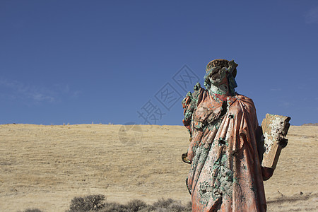 一个无处可逃的死灰复燃的宗教雕像红色上帝黄色女孩女士蓝色草地礼服蓝天图片