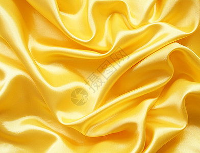 平滑优雅的金色丝绸可用作背景折痕投标布料海浪纺织品织物黄色涟漪材料曲线图片