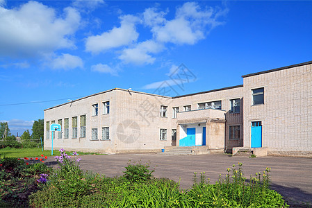 农村街道上的灰砖建筑学校文化蓝色财富车库阳光住房石头鹅卵石人行道图片