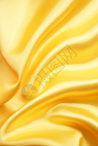 平滑优雅的金色丝绸可用作背景布料材料黄色纺织品投标折痕织物曲线涟漪图片