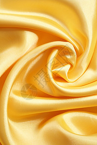 平滑优雅的金色丝绸可用作背景材料涟漪布料曲线纺织品海浪投标黄色折痕织物图片