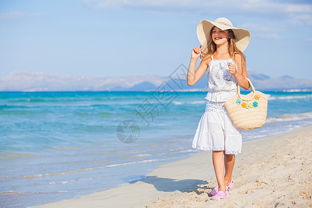 在沙滩上戴着优雅帽子的可爱女孩海滩海洋太阳镜地平线海岸青少年情调享受眼镜假期图片
