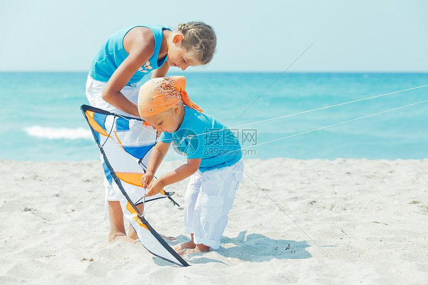 和男孩妹妹在海滩上玩风筝情感女孩娱乐男生孩子们孩子享受热带运动姐姐图片