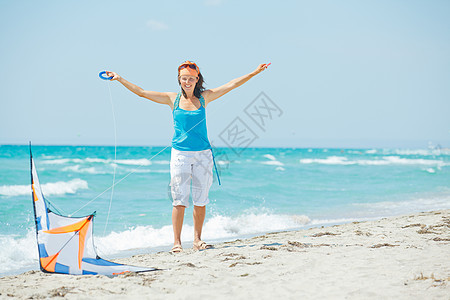 海滩上的女人玩着多彩的风筝晴天空气情感青年喜悦女士幸福童年乐趣热带图片