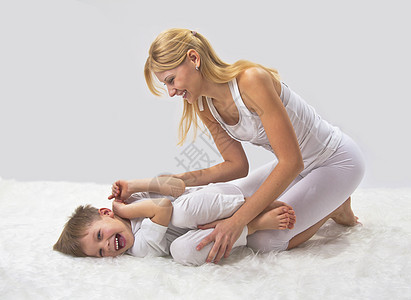母亲和儿子睡前做瑜伽童年女孩妈妈金发女郎活力练习身体幸福乐趣孩子图片
