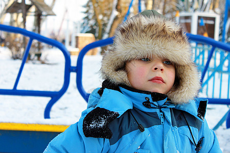 一个男孩在冬季游乐场上图片