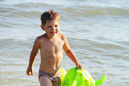 一个男孩在海中游泳蓝色支撑摄影海岸线日光男生快乐孩子男性童年图片