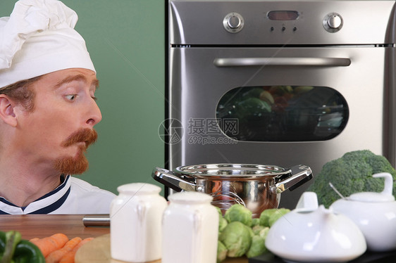 有趣的年轻厨师 奇怪地看着锅衣服烹饪白色工人餐厅午餐工作蔬菜职业餐具图片