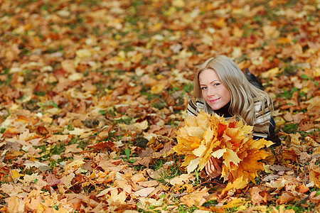 秋叶中的妇女脚尖女孩叶子成人团体女性毛衣头发幸福微笑公园图片