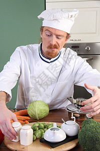 在厨房准备午餐的年轻厨师帽子盘子白色餐具男性美食职业烤箱餐厅烹饪图片
