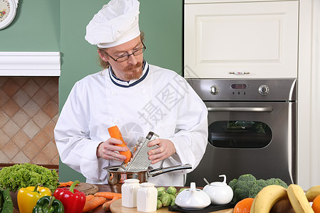在厨房准备午餐的年轻厨师餐厅食物帽子工作美食白色蔬菜男性烤箱男人图片