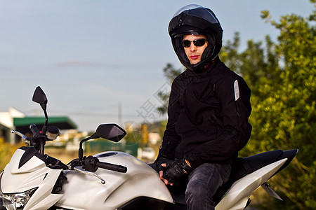 骑摩托车的男人发动机沥青男性运输姿势齿轮农村头盔车辆太阳镜图片