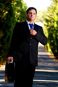 在路上拿着手提箱的商务人士套装快乐领带乐趣公园工作孤独商业男人小路图片